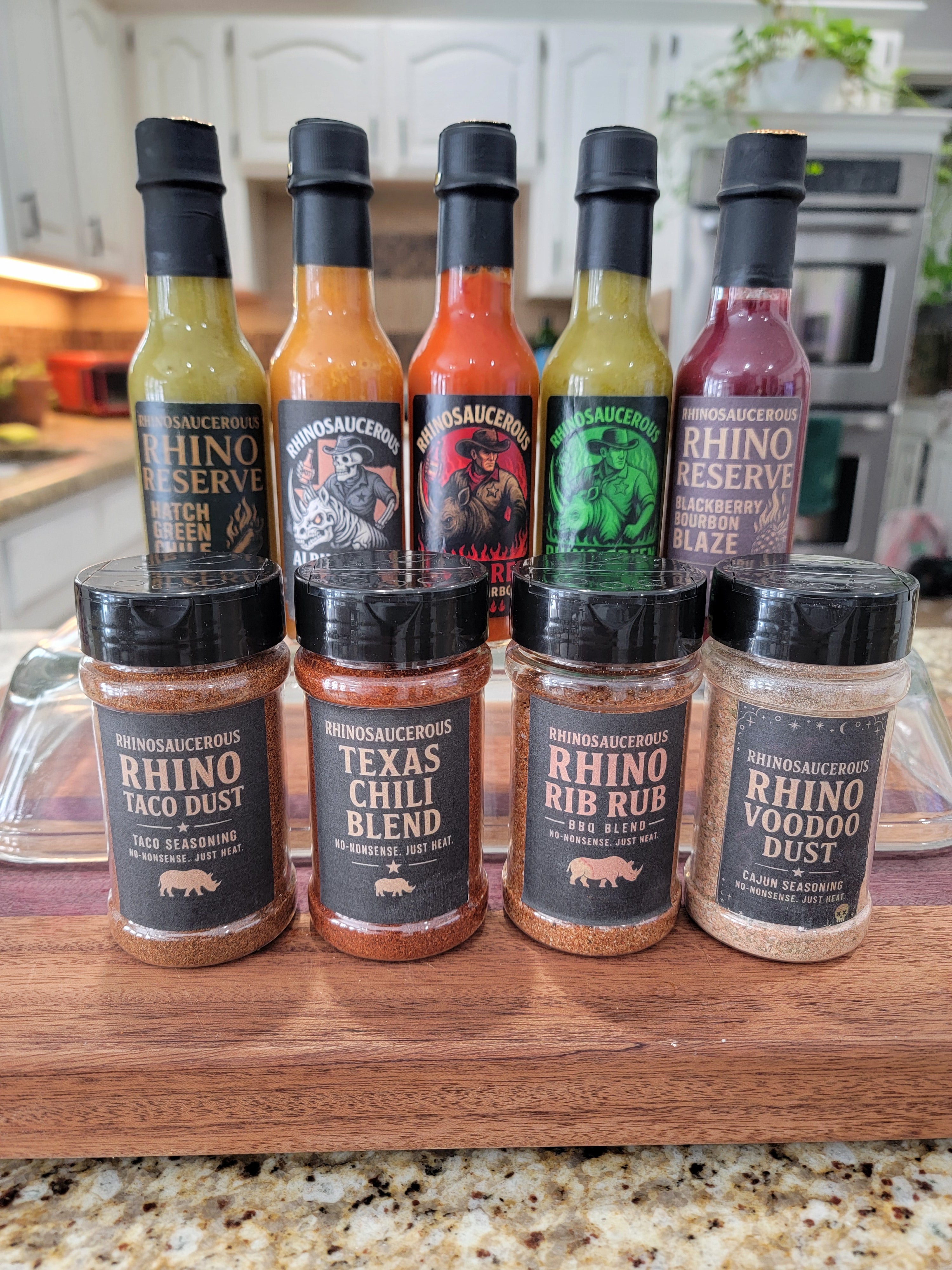 One of each RhinoSaucerous small batch hot sauce and spice collection on a wooden cutting board
